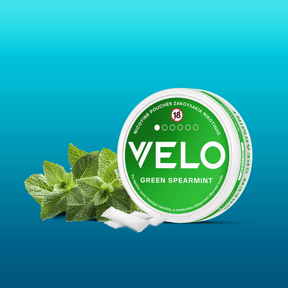 A round container of FREE SAMPLE nicotine pouches, honored as Product of the Year 2025 in Greece, sits against a blue gradient background with fresh mint leaves and white pouches beside it.