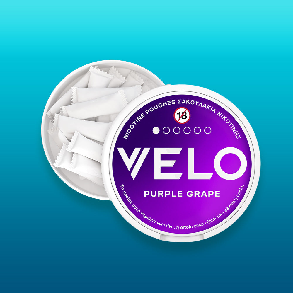 Round white container of FREE SAMPLE nicotine pouches, open to show white pouches inside. The lid displays purple and white branding with Greek text, a no-under-18 symbol, and celebrates Product of the Year 2025 in Greece.