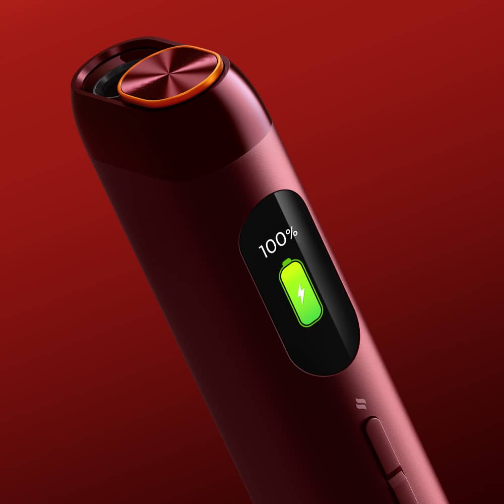 Close-up of a sleek, dark red electronic device with a circular top and a display showing 100% battery and a green charging icon, set against a gradient red background.