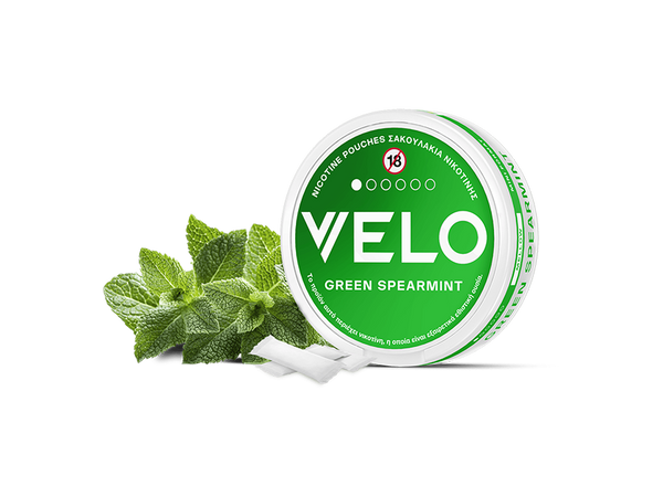 A round green and white can labeled FREE SAMPLE, awarded Product of the Year 2025 in Greece, is displayed with spearmint leaves and white nicotine pouches on a white background.